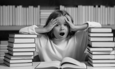 Kitap yığınları olan bir okul çocuğu. Okuluna geri dön. Çocuk eğitimi ve okul konsepti. Kütüphanede kitap okuyan öğrenci portresi. Çocuk gelişimi, okumayı öğren.