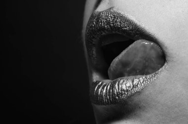 Dil yalayan dudaklar. Ağzında altın boya var. Altın dudaklar. Lüks altın dudaklar makyaj. Yaratıcı metalik rujlu altın dudaklar. Altın metal dudak. Şehvetli kadın ağzı, sıkı tutun, makro