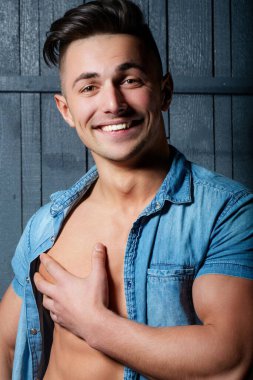 Kaslı vücudu olan mutlu, gülen bir adam. Seksi erkek çıplak gövde. Kot pantolonlu adam. Seksi vücutlu genç kaslı erkek model. Güzel gövde. Kaslı erkek gövdesi, güçlü omuzlar.