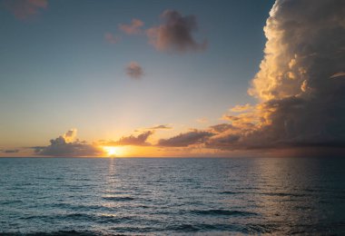 Gün batımlı ya da gün doğumlu deniz sahili. Gün batımı denizi üzerinde bulutlu bir manzara. Tropik plajda gün batımı. Durgun, sakin denizin doğa gün batımı manzarası