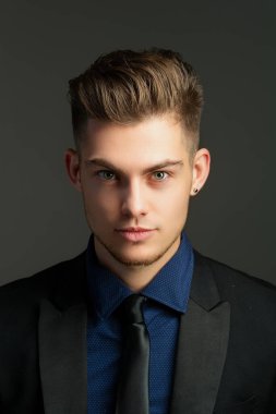 Takım elbiseli yakışıklı adamın portresi. Genç adam manken portresi. Erkek yüzü. Genç yakışıklı adam. Kendine güvenen erkek model. Adam gururlu görünüyor. Çekici bir adamın yakın çekim yüzü. Zarif adam.