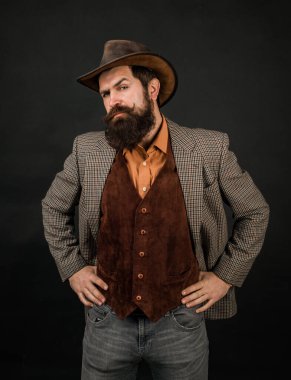 Kovboy şapkalı yakışıklı, eski moda hippi kovboy. Amerikalı kovboylar. Kovboy şapkası takan sakallı adamın portresi. Kovboylar gibi. Retro kovboy. Yakışıklı, sakallı, maço.