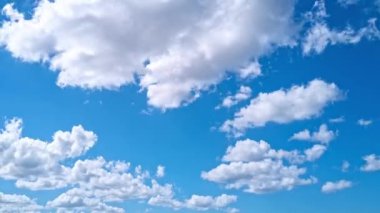 Gökyüzü zaman ayarlı. Hareket eden bulutlar ve güneş. Beyaz kabarık bulutlar mavi gündüz vakti gökyüzünde yavaşça süzülür. Güzel gökyüzü hareket ediyor. Beyaz kümülüs ve sirrus