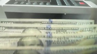 Banknotların içinde nakit para var. Bankacılık ve finansal konsept. Elektronik para sayacı ve yeni 100 dolarlık banknotlar. Sayaç makinesi 100 dolar banknot sayıyor.