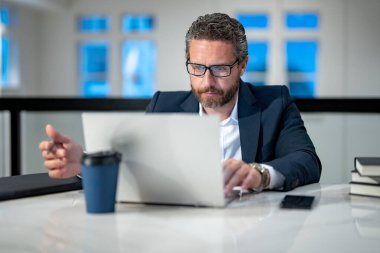Office worker with laptop at office. Ofice employee remote working in modern office. Businessman have on line meeting. Business man using computer in office. Modern offices workplace