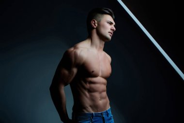 Kaslı, kaslı, kaslı ve güçlü vücutlu bir adam. Güçlü kasları olan baştan çıkarıcı erkek model. Çekici üstsüz adam. Kaslı vücutlu genç ve seksi bir adam. Seksi erkek model.