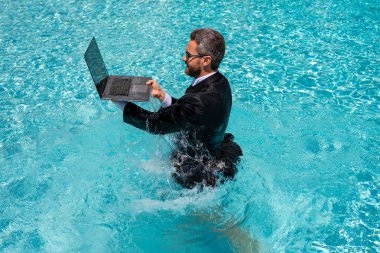 Serbest çalışma, uzaklık, online çalışma, e-çalışma. Yaz işi. Heyecanlı takım elbiseli iş adamı bilardoda dizüstü bilgisayarla atladığı için heyecanlı. İşadamı internette çalışıyor. Mizah işi konsepti