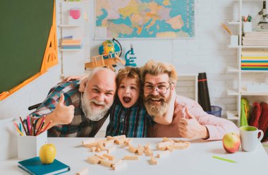 Büyükbaba ve torunun oynadığı ve öğrendiği portre. Büyükbaba ve oğul arasındaki aile ilişkisi. Dedem liseli çocuklara ders veriyor. Öğretmenler ve öğrenciler oyun oynuyor