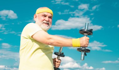 Özgürlük emekliliği kavramı. Dedem halterle egzersiz yapıyor. Son sınıf öğrencileri için spor