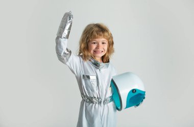 Uzay kaskı ve metal kıyafetiyle astronot olmaya çalışan harika bir çocuk.