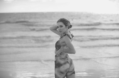 Woman in bikini on the tropical beach. Summer portrait of young beautiful girl on beach with bikini. Beautiful young woman on the beach. Freedom and carefree concept