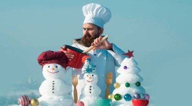 Kış aşçısı. Kar adam aşçı aşçı arka planda kar arka planı. Kardan adamla Noel afişi. Kardan adamla birlikte kış tebrik kartı. Kış arkaplanı
