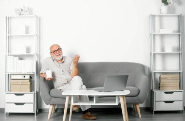 Ofiste ya da evde çalışan gri saçlı son sınıf öğrencisinin portresi. Video çevrimiçi konferans. Çevrimiçi toplantı, video görüşmesi, uzaktan kumanda. Çevrimiçi, çevrimiçi kurslar öğreniliyor