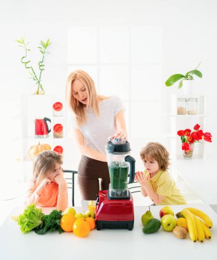 Mutfakta mutlu bir aile. Anne ve çocuklar sebze ve meyve hazırlıyorlar.