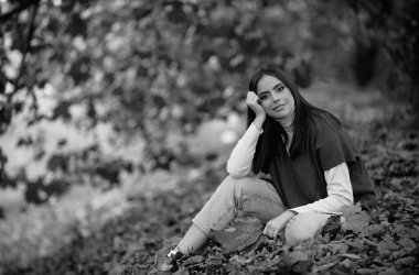 Sarı akçaağaç yaprağıyla sonbahar kadını, açık hava portresi. Sonbahar yapraklı güzel bir model, sonbahar parkında sarı akçaağaç. Sonbahar kızı sonbahar mevsiminde güneşli havanın tadını çıkarıyor.