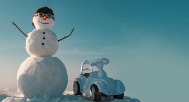 Dışarıda kardan adam sürücüsü var. Kardan adamla Noel afişi. Yeni yıl tebrik kartı ile kardan adam