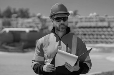 Yeni evde profesyonel inşaat işçisi. Dışarıdaki işçilerin portresi. İnşaat alanında kasklı inşaat işçisi. İnşaat üniformalı mühendis.