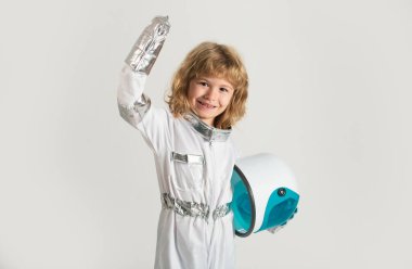 Çocuk elinde kaskla astronotçuluk oynuyor. Küçük mutlu uzay adamı