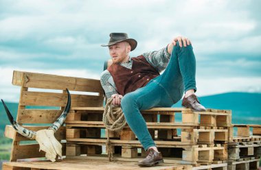 Portrait of farmer or cowboy outdoor. Stylish sexy man looking away clipart