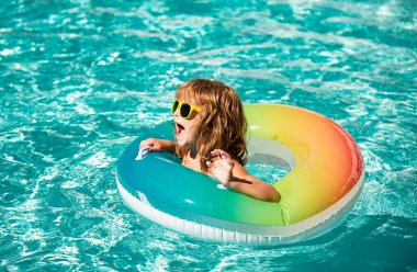 Aquapark yaz tatili. Havuzdaki çocuk. Şişme lastik çemberdeki mutlu çocuk.