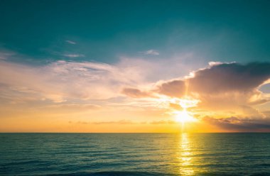Tropikal deniz okyanusunda gün batımı ve gündoğumu bulutları. Seyahat tatili afişi. Manzara gökyüzü ve yansıma ışınları. Pasifik Okyanusu. Alacakaranlık, denizde alacakaranlık. Sakin, altın gökyüzü arka planı