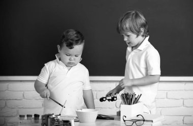 Children boys brothers drawing cute draw using colored pencils at school or kindergarten. Kids art, creativity children concept