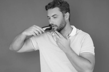 Erkek saç stili, saç kesimi. Makasla saç kesen bir milenyum adamı. Erkek saç bakımı, güzellik berberi konsepti. Sakallı adam, makasla. Makasla saç kes. Erkek saç stili ve makasla saç kesimi