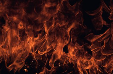 Siyah arka planda yangın alevleri. Ateş, izole edilmiş, soyut bir yapı. Yanma efektiyle yanan bir patlama. Duvar kağıdını ateşle, kopyalama alanı ile soyut sanat deseni