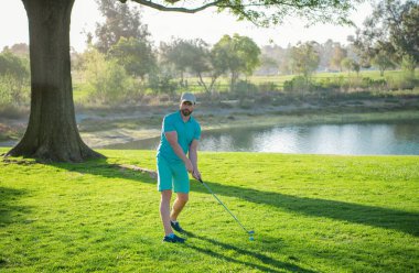 Golf sahasında golf oynayan bir adam.