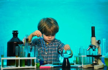 Okulun ilk günü. Okul konsepti. Anaokulu öğrencisi. Masada mutlu gülümseyen öğrenci çizimleri. Okul çocuğu. okul çocuğu. Kimya gösterisi..