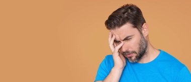 Üzgün adamın migreni tuttu. Güçlü baş ağrısı olan bir adam. Stresli, baş ağrısından yorgun bir adam. Baş ağrısı, yorgunluk ve stres, migren. Baş ağrısı konsepti