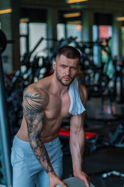 Motivated male athlete does exercise, bodybuilding workout at gym. Strong muscular man has fitness workout. Sport and healthy lifestyle concept. Muscular man workout in gym doing exercises with