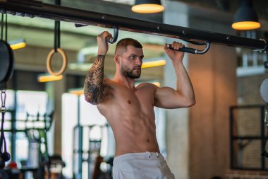 Man exercising with dumbbell. Male bodybuilder doing weight lifting workout at gym. Training with barbell. Muscled man strong muscular fit man workout with heavy weight. Exercises for muscular body