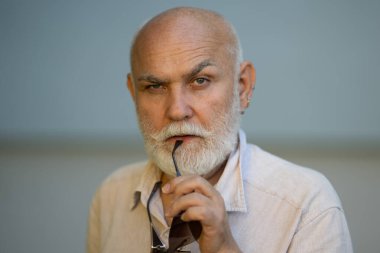 Olgun büyükbaba portreyi kapat. Gri saçlı, beyaz sakallı yaşlı adam. Olgun bir adam. Sakallı, olgun bir adamın yüzü. Gri sakallı, olgun, yaşlı bir adamın vesikalığı.