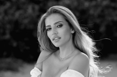 Bahar Parkı 'nda şehvetli bakışları olan seksi bir kadın. Dışarıda güzel bir kadın modelin güzel portresi var. Güzel genç kız bahar parkında dinleniyor.