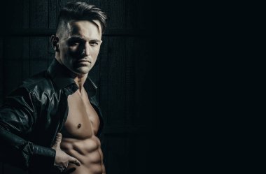 Karanlık arka planda seksi, genç, çıplak bir adam. Baştan çıkarıcı gay