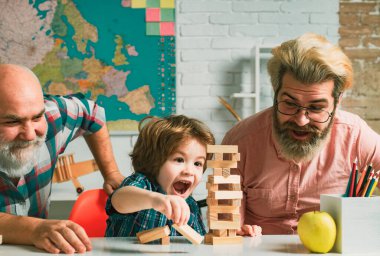 Mutlu küçük çocuk baba ve büyükanne ve büyükbaba eğlence zamanı. Mutlu çok nesilli aile evde Jenga oynuyor.