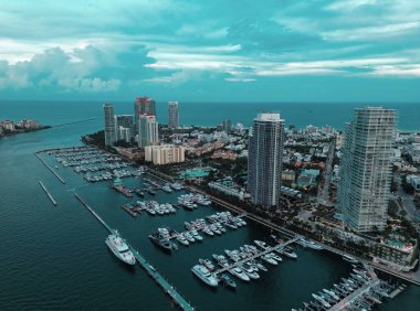 Miami Beach silueti, Florida. Miami Beach şehrinin hava aracından gökyüzü görüntüsü. Gökdelenler ve limanlar. Miami Sahili kıyısı marinalarla kaplı. South Point Park 'tan Miami plaj manzarası