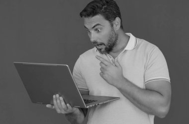 Stüdyoda dizüstü bilgisayarla çalışan adam. Adam dizüstü bilgisayardaki e-postaları kontrol ediyor, sosyal ağda mesaj yazıyor, internet kullanıyor, dizüstü bilgisayarlarda bilgi arıyor. Stüdyoda izole edilmiş dizüstü bilgisayar kullanan adam