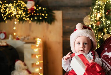 Noel Baba şapkalı şirin bir bebeğin Noel portresi.