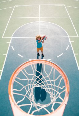 Çocuk bahçesinde basketbol oynayan çocuğun üzerinden açılı görüş