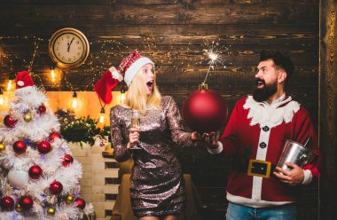 Merry Christmas and Happy New Year. Fashion couple over Christmas tree lights background. Sensual couple in Home Christmas atmosphere clipart