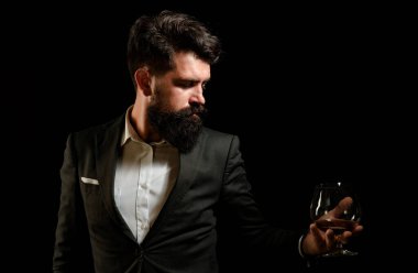 Sakallı yakışıklı adam elinde bir bardak konyak tutuyor. Tatma ve degukasyon konsepti. Barmen ya da barmen konyak servisi yapar.