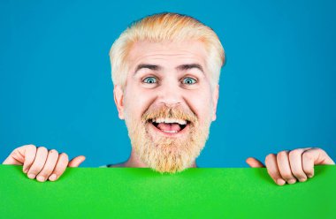 Boş kağıtlı mutlu adam. Reklamcılık. İş kavramı. İndirim. İş adamı elinde boş bir pankart tutuyor ve yere bakıyor