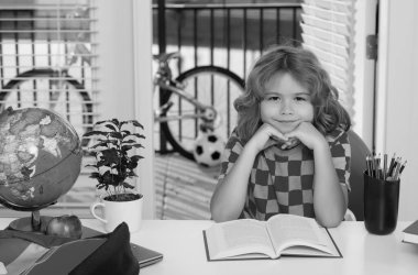 Child reading book. School child studying in classroom at elementary school. Kid studying on lesson in class at elementary school
