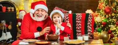 Mutlu büyükbaba ve oğul Noel kurabiyesi süslüyor. Noel ailesi. Noel 'den önceki sabah. Noel arşivi