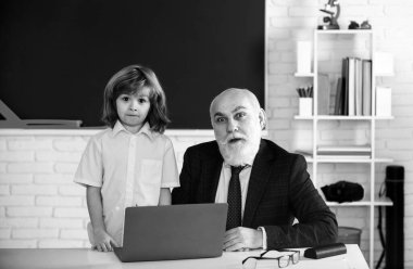 Kıdemli öğretmen ve çocuk öğrenci sınıfta. Eğitim konsepti. Okul öğrenme konsepti. Erkek ilkokulu