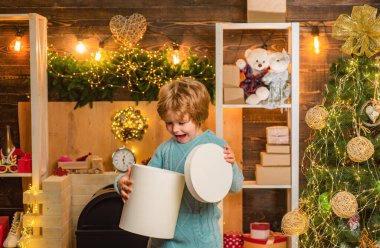 Hediye ile eğlenen çocuk modelleri. Yetenekli çocuk. Noel'den önceki sabah. Çocuklar tatilin tadını çıkarır. Mutlu Noeller dileriz