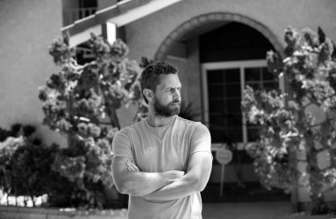 Adam yeni evinin önünde duruyor. Satın al, sat, emlak, mülk, ev sigortası konsepti