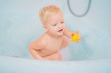Çocuklar küvette oynuyor. Bebek hijyeni, sağlık ve cilt bakımını yıkayın. Childs hijyeni. Banyo oyuncağı ördek. Köpük banyosu